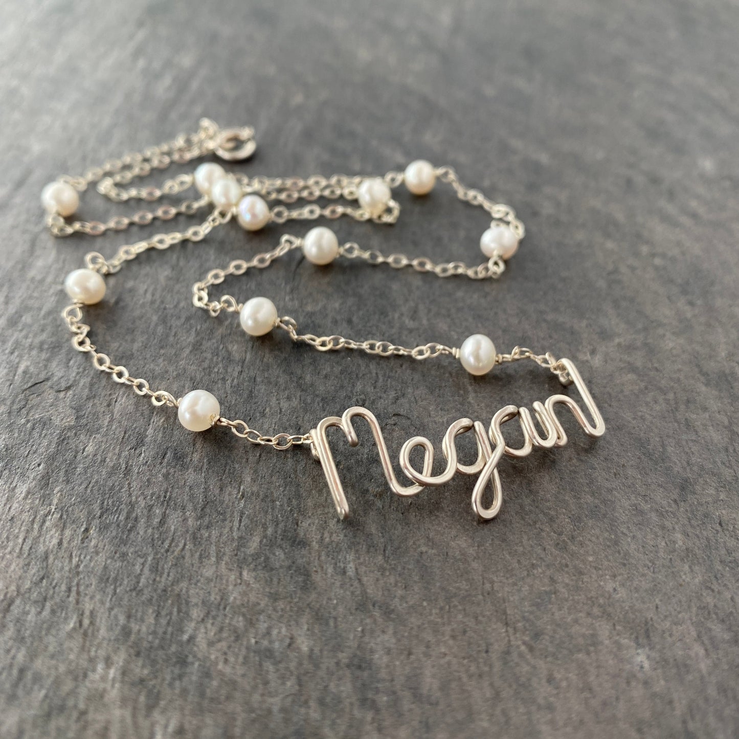 Name Necklace. Off White Freshwater Pearl Name Necklace in Sterling Silver. Script style font.